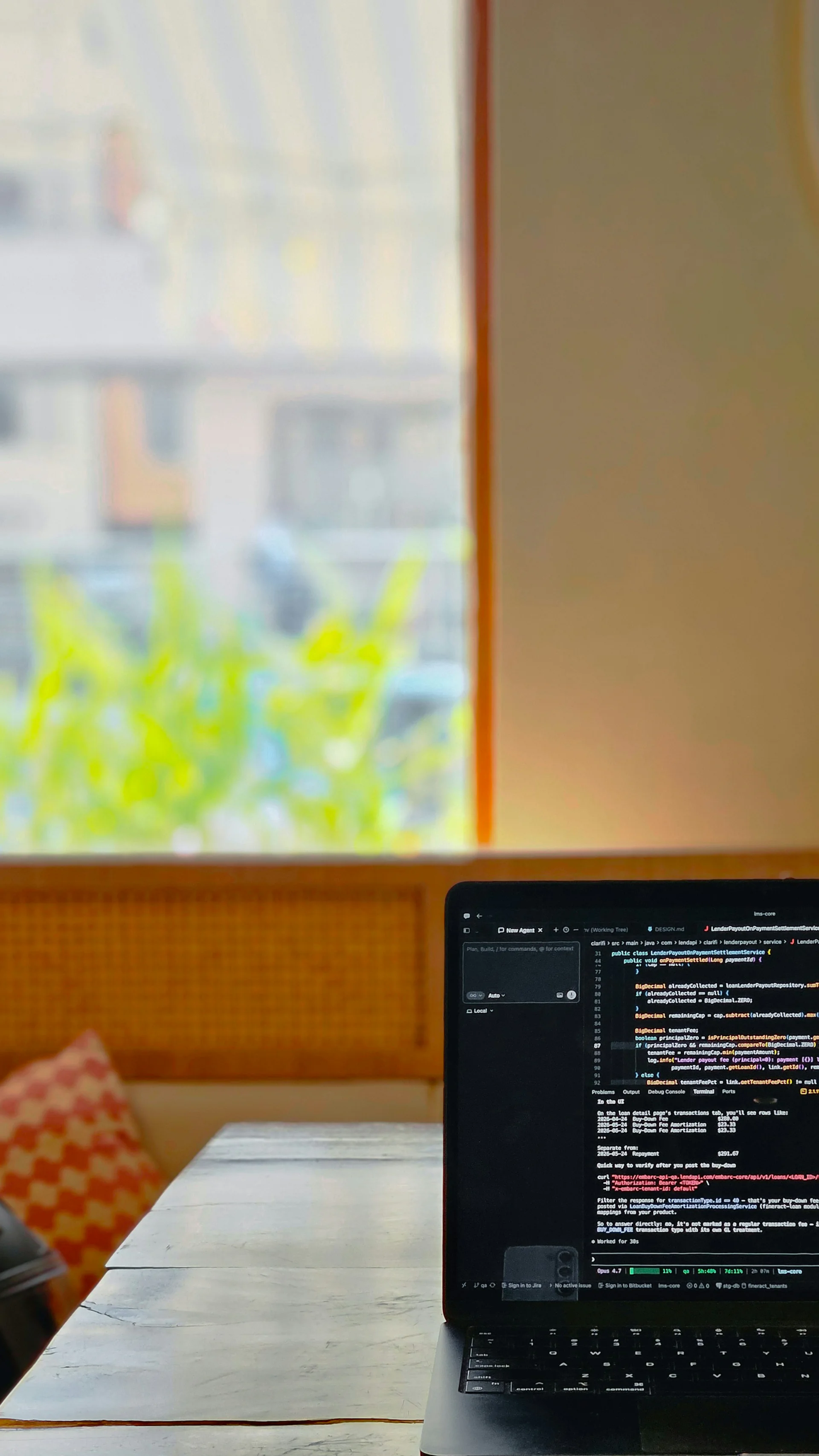 窓辺の自然光に置かれたコード表示中のノートPC