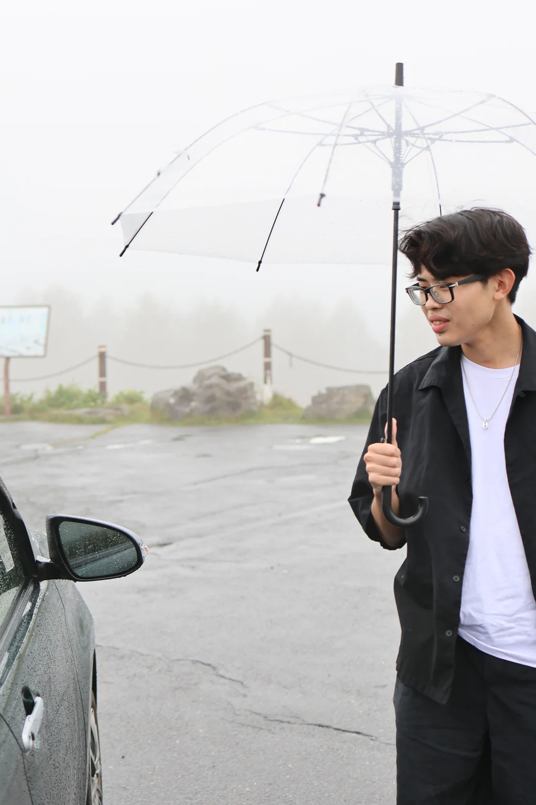 Yuto Matsui looking toward a car in the rain
