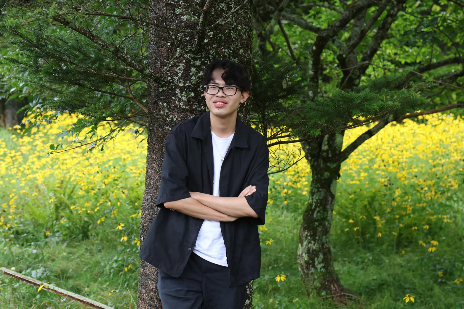 Yuto Matsui leaning against a tree among summer flowers