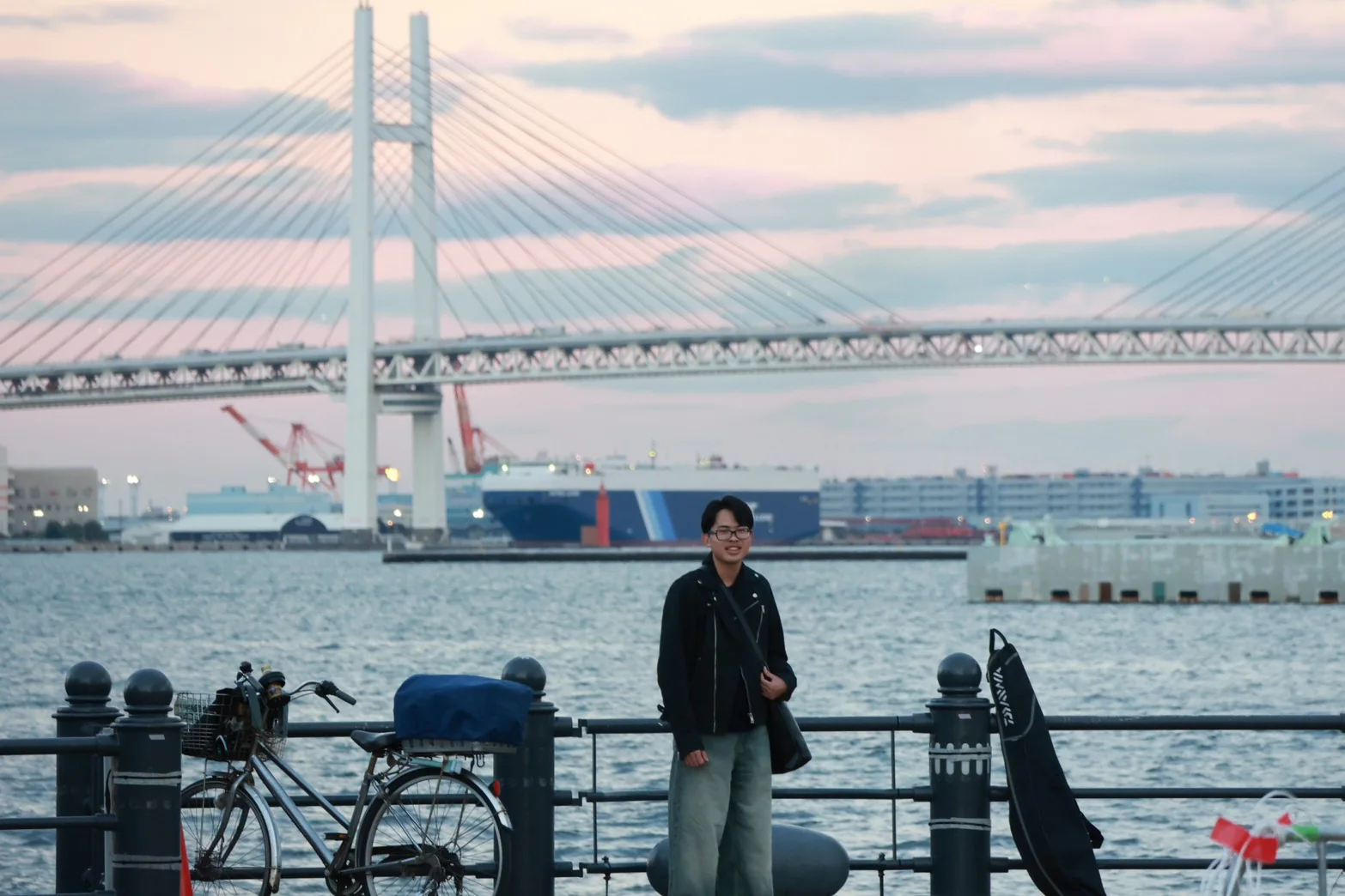 横浜港と橋を背景に立つYuto Matsui