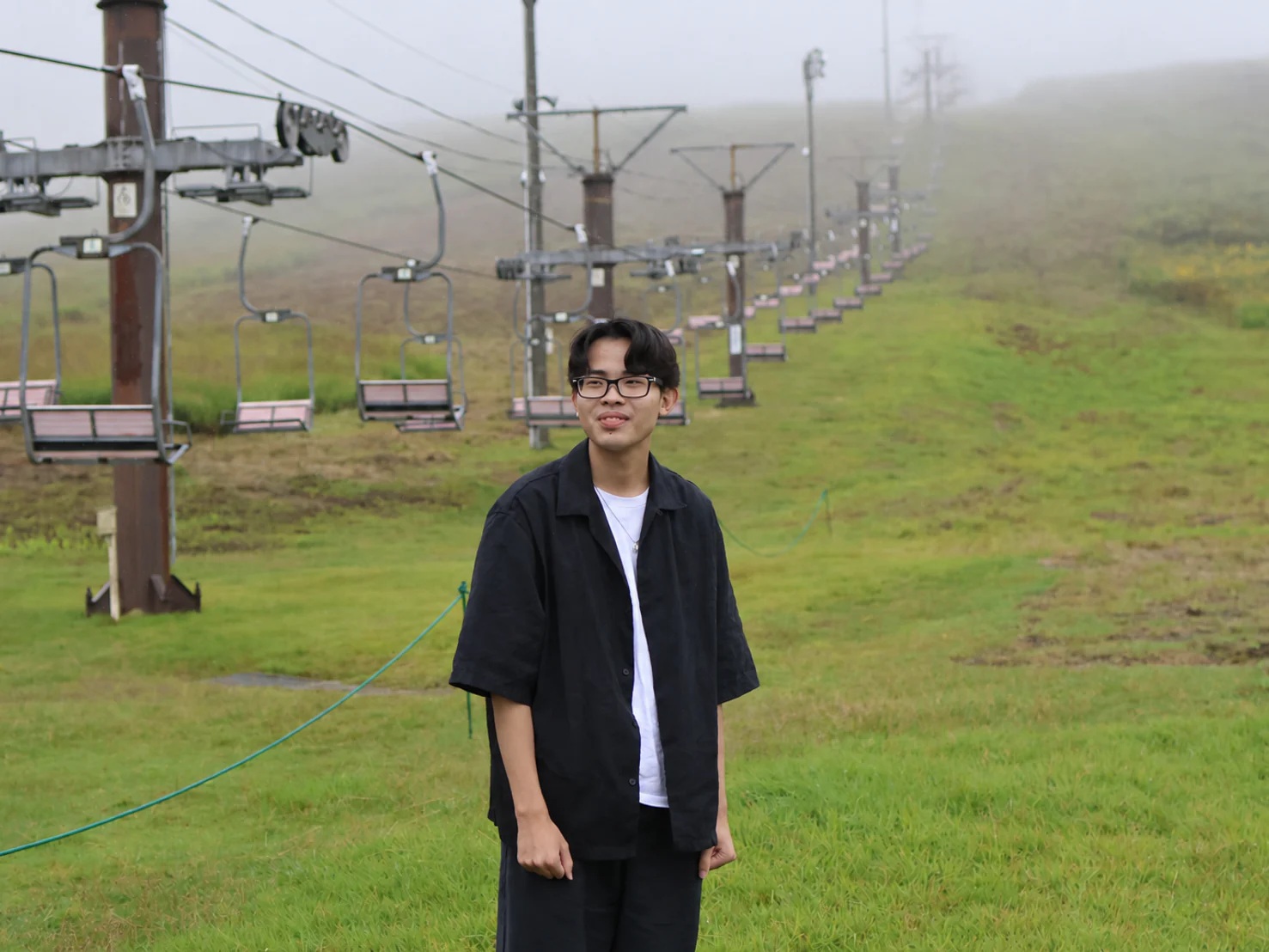 Yuto Matsui standing beside a ski lift fading into mist
